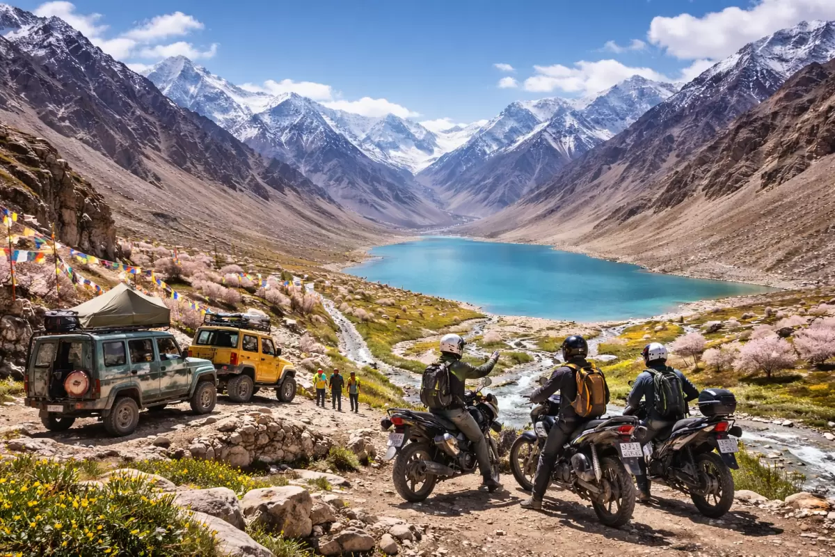 Adventure bikers and off-road vehicles overlooking stunning turquoise lake and snow-capped Himalayan mountains in spring