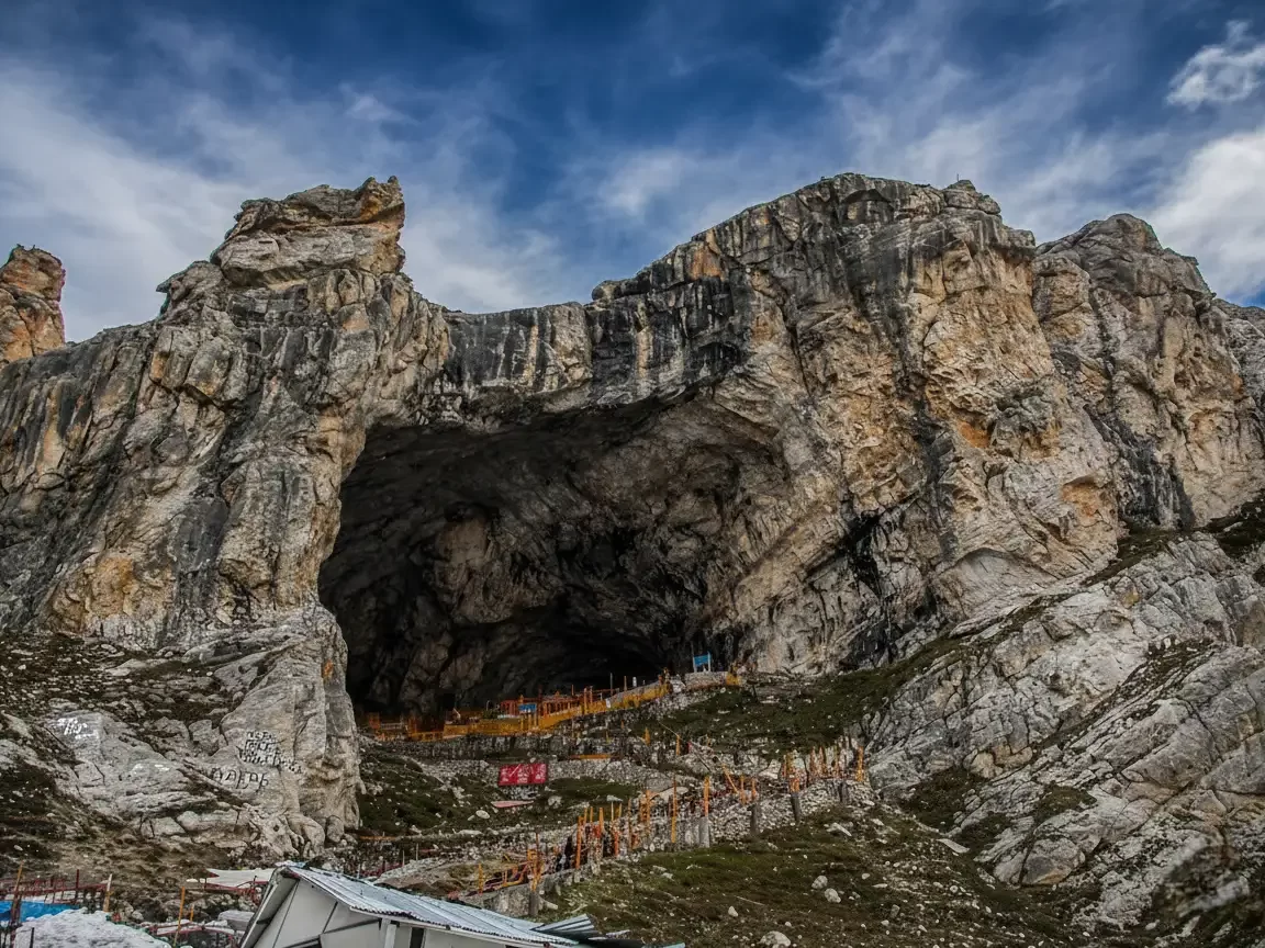 Epic Amarnath Cave entrance rocky Himalayan portal pilgrims flags, colorful shrines stairs blue skies towering peaks, perfect Jammu Kashmir ice lingam darshan yatra package.