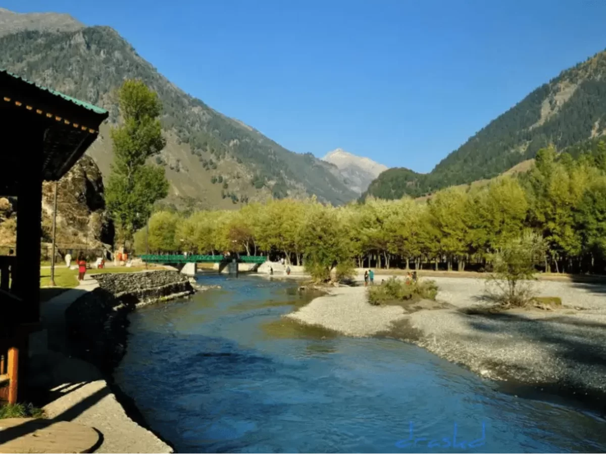 Bridge over Lidder River at Betaab Valley Pahalgam during sunny day, featuring pine trees mountains and turquoise waters, perfect adventure experience Kashmir tour packages.