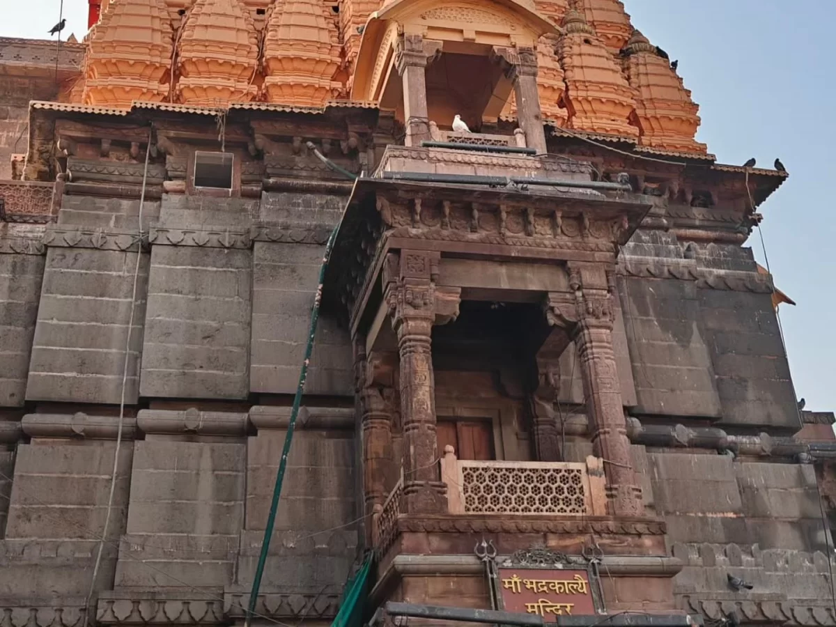 Shree Mahakaleshwar Temple at Ujjain during clear daylight, featuring orange shikhara stone arches Marathi signage, perfect spiritual Madhya Pradesh tour package.