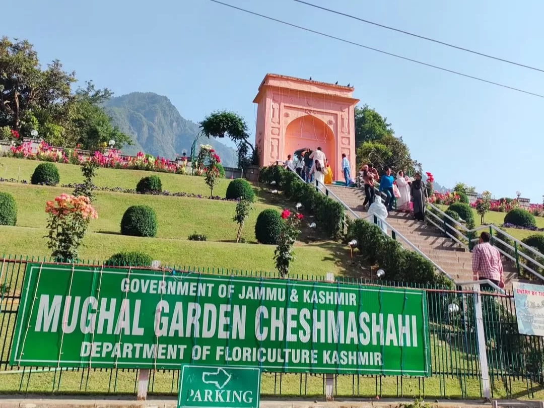 Chashme Shahi Mughal Garden Srinagar main entrance pink arch Government Floriculture Department sign Zabarwan hills terraced flowers parking featured in Kashmir tour packages