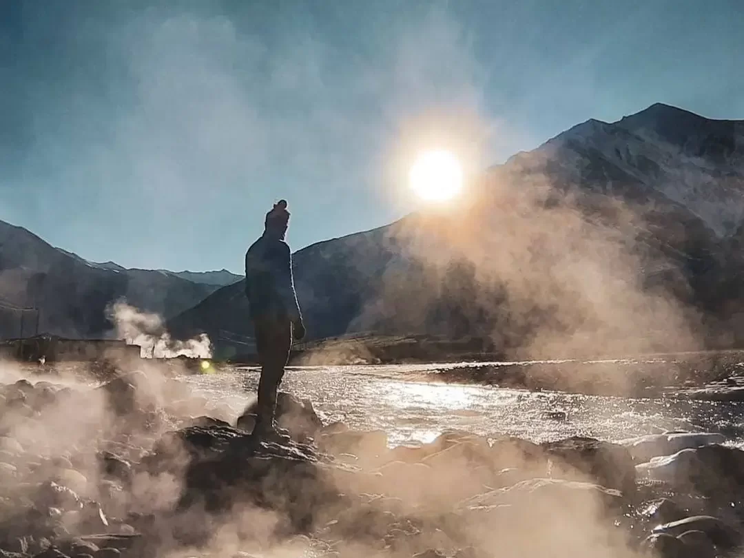 Chumathang Hot Springs Ladakh Indus River sunset steam hiker, snowy Zanskar peaks golden light rocky banks, perfect Leh Tso Moriri therapeutic geothermal package. 