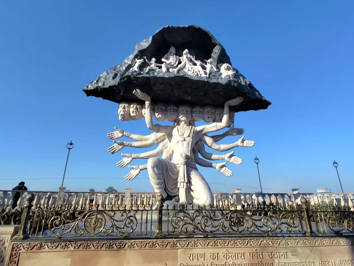Ravana lifting Kailash statue at Mahakal Lok Corridor Ujjain during clear daylight, featuring multi-arm figure rock canopy, perfect spiritual Madhya Pradesh tour package.