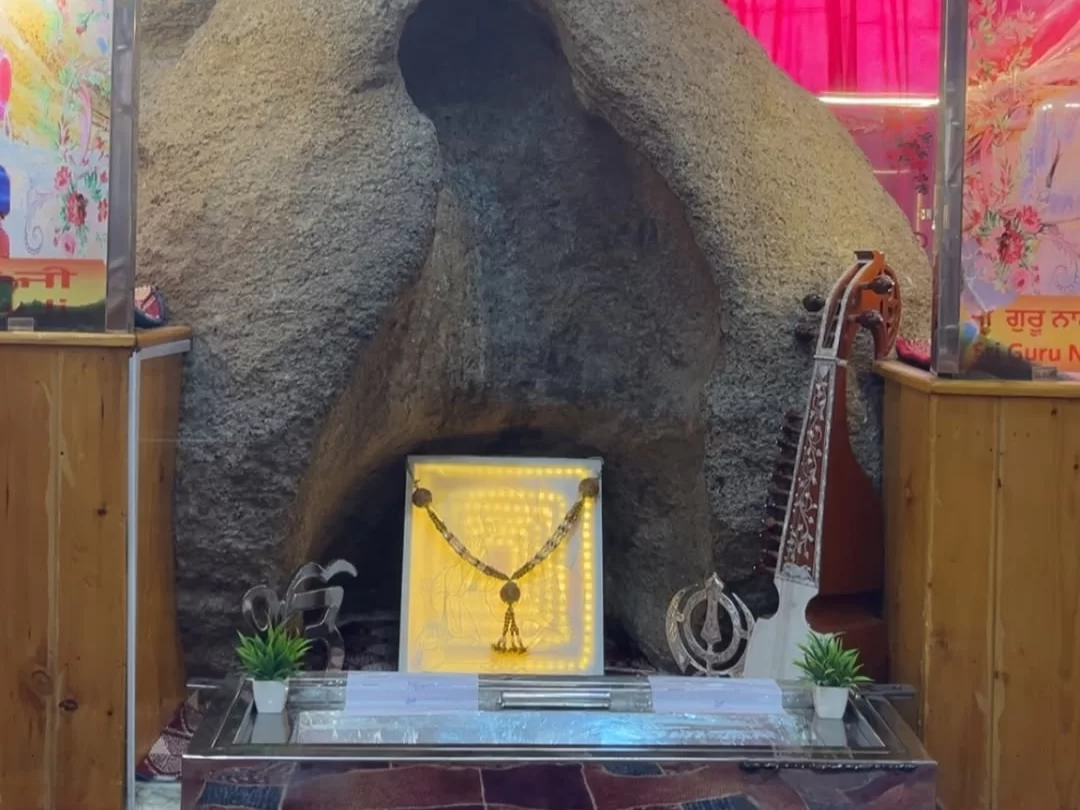 Gurdwara Pathar Sahib Leh Ladakh sacred rock shrine with illuminated Pathar boulder Khanda garlands sarangi plants portraits red drapes, Guru Gobind Singh miracle site essential Ladakh spiritual stop.