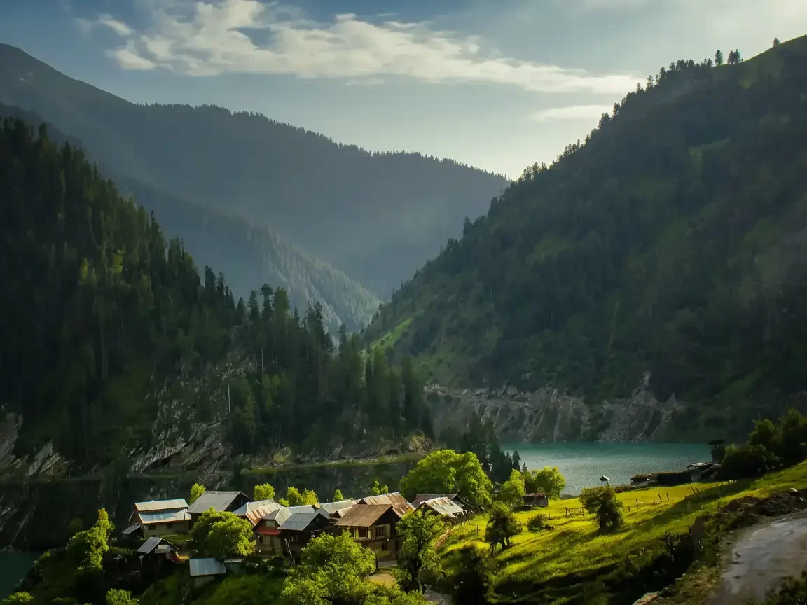 Wooden houses at Gurez Valley during golden hour, featuring pine mountains and turquoise lake, perfect adventure experience Srinagar tour package.
