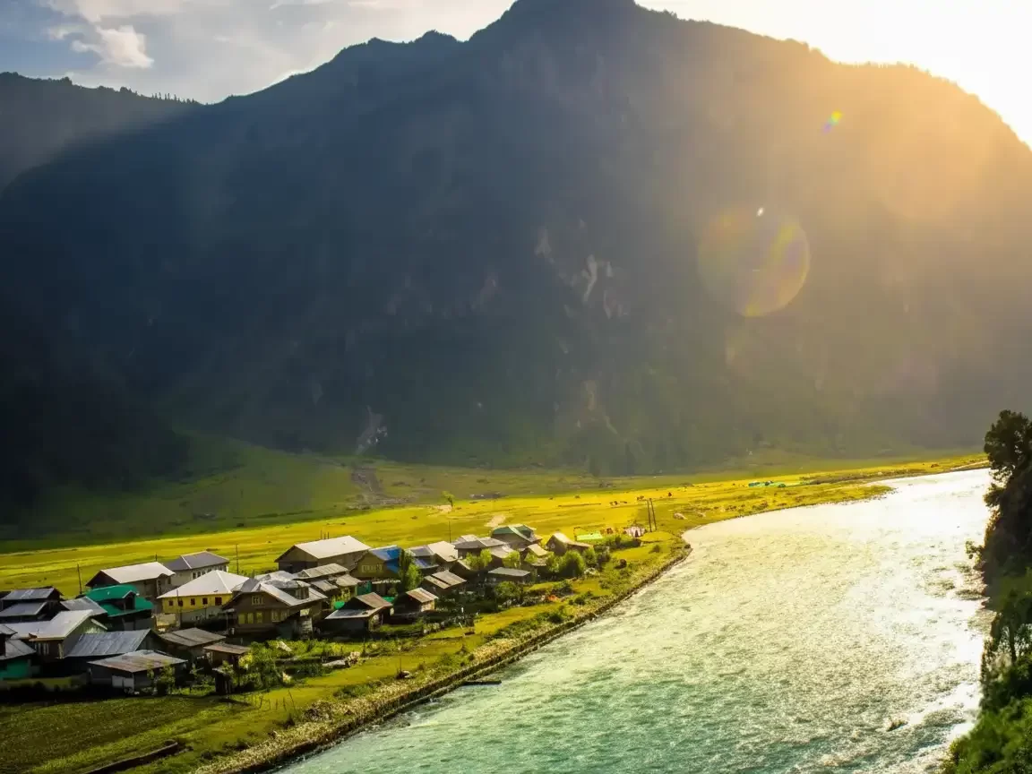 Gurez Valley riverside villages golden hour Kashmir, featuring wooden houses green meadows turquoise river towering mountains sunset glow, perfect cultural adventure Srinagar tour packages.