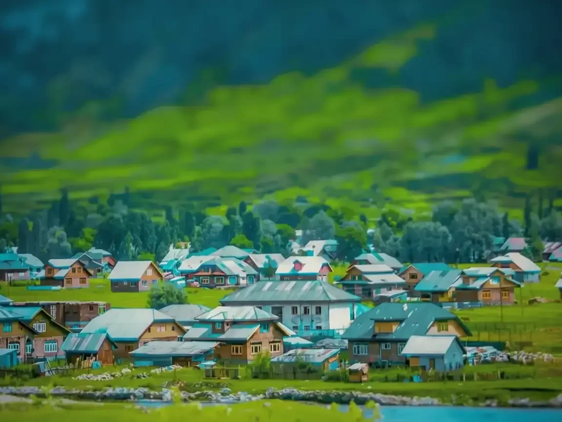Gurez Valley villages Kashmir misty day, featuring wooden roofed houses green meadows mountains river backdrop, perfect adventure experience Srinagar tour packages.