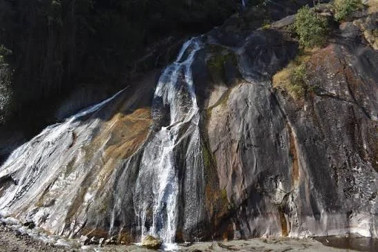 Matu Waterfall near Mechuka featuring cascading streams over smooth rocky cliffs, perfect Arunachal Pradesh tour package experience.
