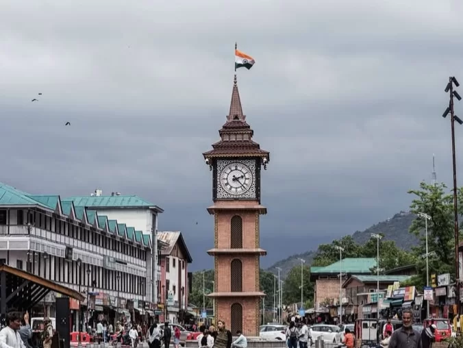 Clock tower Ghanta Ghar at Lal Chowk Srinagar city center with Indian flag shops crowd featured in Kashmir Srinagar tour packages