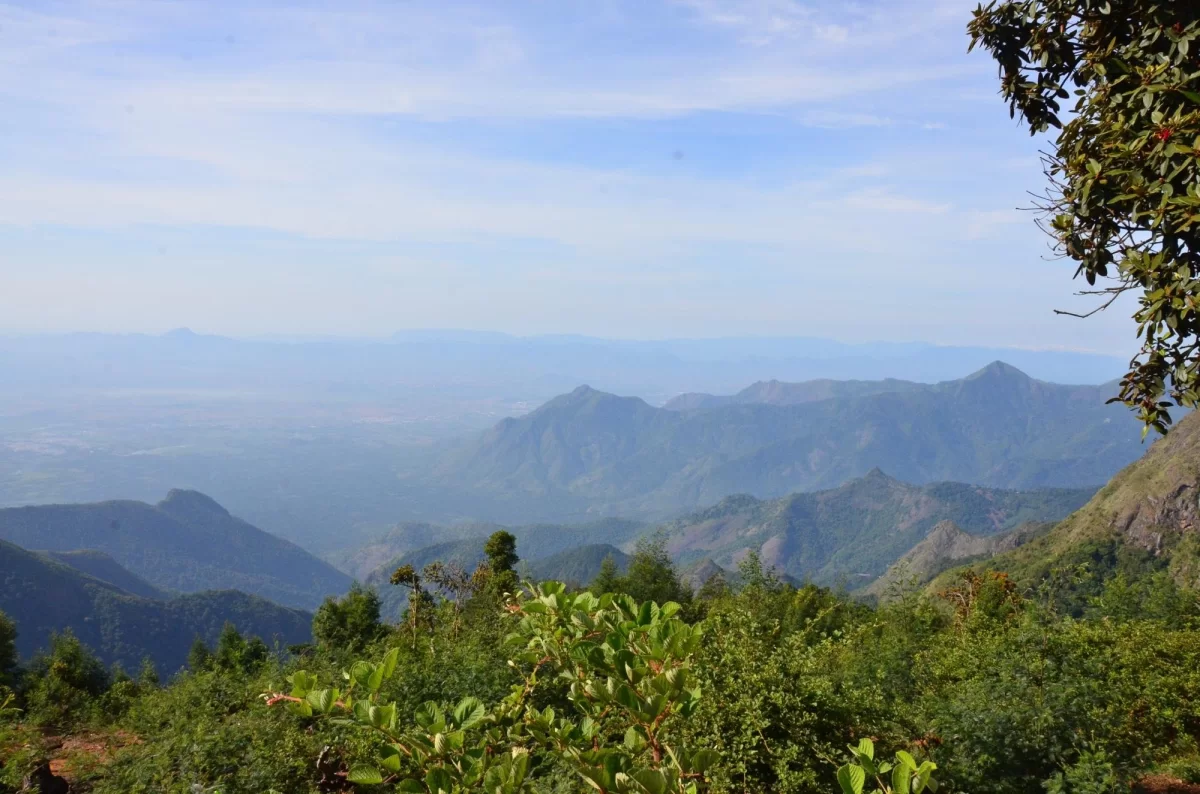 Moir Point at Kodaikanal during clear afternoon, featuring panoramic valley views, distant hills, forests, perfect adventure experience Tamil Nadu tour packages.
