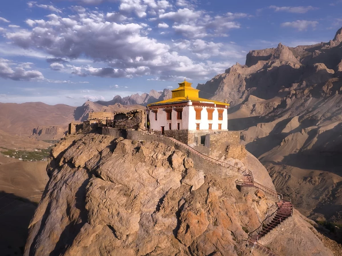 Mulbekh Gompa white monastery golden roof perched atop sheer rocky cliff staircase rugged arid Zanskar mountains blue skies Ladakh, perfect Kargil Leh Himalayan Buddhist cliffside tour.