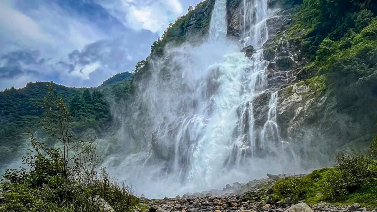 Navika Waterfall near Bhalukpong featuring powerful gushing water, dramatic cliffs, and lush green surroundings, perfect Arunachal Pradesh tour package experience.
