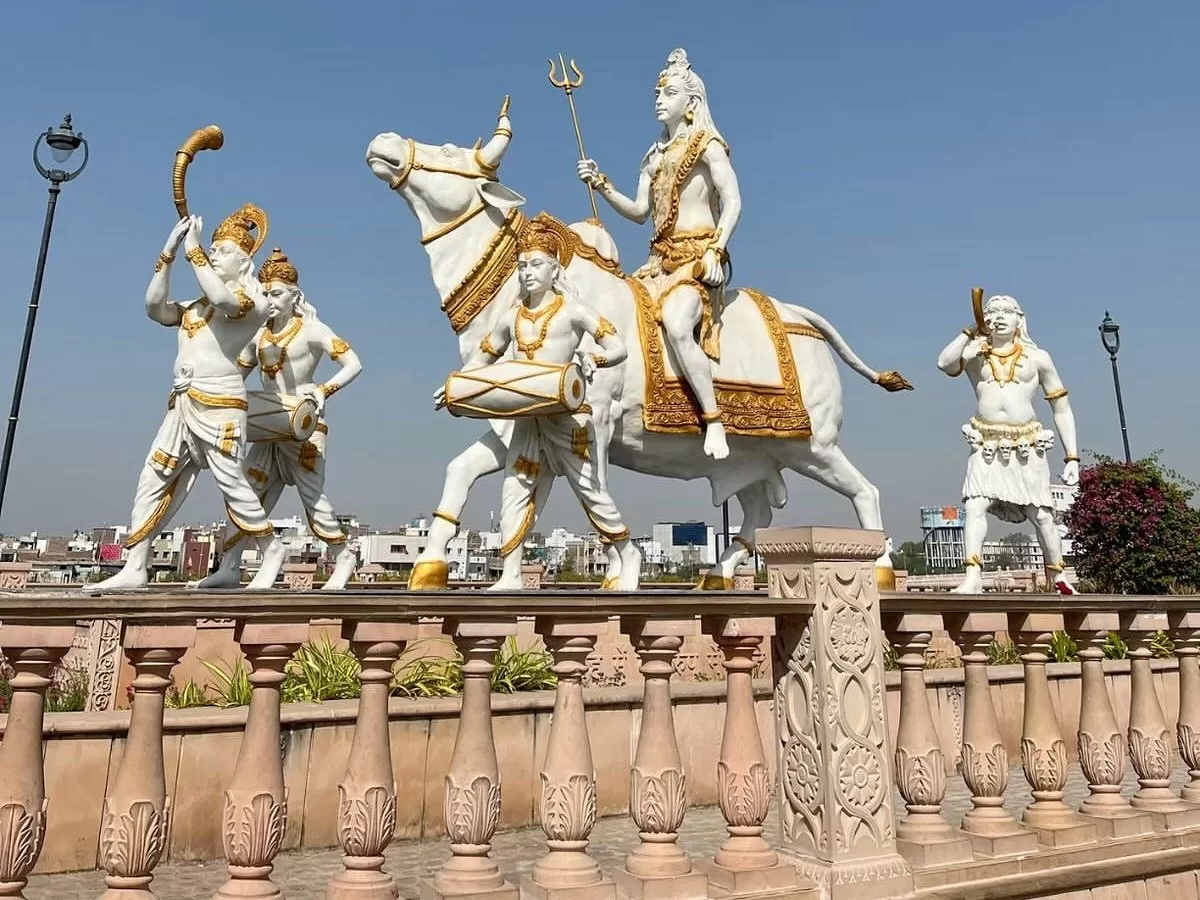 Shiva on Nandi with Ganas at Mahakal Lok Corridor Ujjain during clear daylight, featuring trishul drum white marble sculptures, perfect spiritual Madhya Pradesh tour package.
