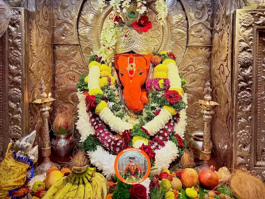 Shree Navshya Ganpati Mandir idol in Nashik Maharashtra decorated with vibrant flower garlands fruits and ornate silver backdrop inside temple shrine