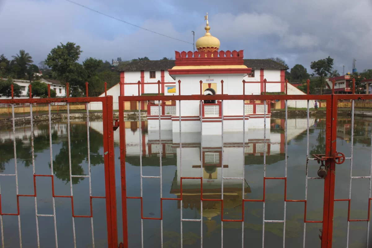 Shri Omkareshwara Temple at Madikeri during cloudy day, featuring Indo-Islamic architecture, dome, pond reflection, fence, perfect cultural experience Coorg tour packages.