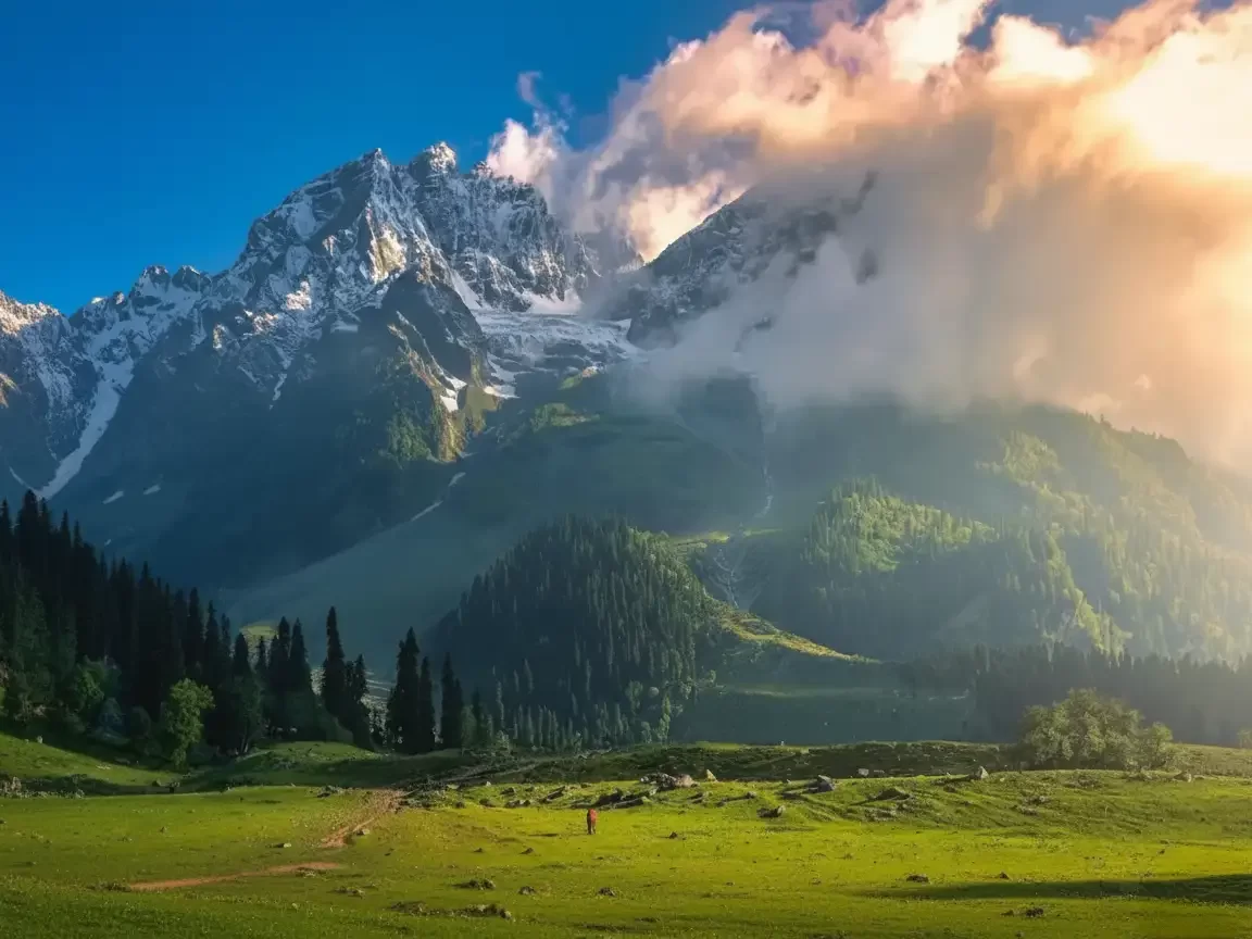 Snowy peaks at Sonamarg during sunset clouds, featuring pine forests & lush meadows, perfect romantic experience Kashmir tour packages. 