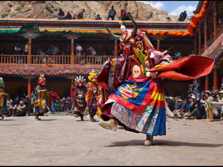 Horned cham dancer at Spituk Gustor Festival in Ladakh during daytime, featuring colourful monastery courtyard, perfect Ladakh cultural tour package