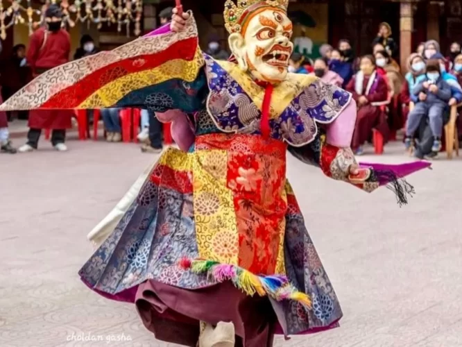 Masked cham dance at Spituk Gustor Festival in Ladakh during daytime, featuring colourful silk robes, perfect Ladakh cultural tour package