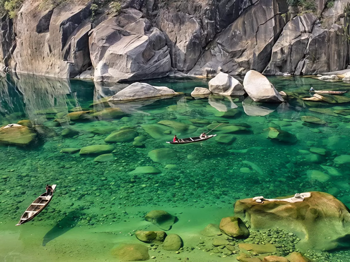 Umngot River Dawki Meghalaya crystal clear turquoise waters massive boulders rocky cliffs wooden boats serene peaceful vibe perfect river adventure Meghalaya tour package.