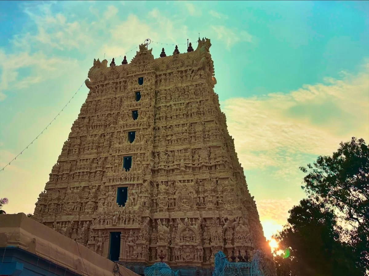 Towering gopuram of Suchindram Thanumalayan Temple during sunset, featuring intricate carvings and blue sky, perfect Kanyakumari tour package.