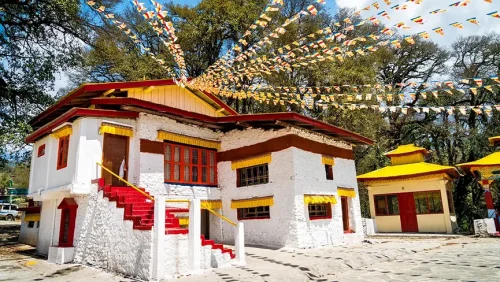 Ugyenling Monastery in Tawang featuring traditional white-washed architecture, colorful prayer flags, and peaceful forested surroundings, perfect spiritual experience with Tawang tour package.