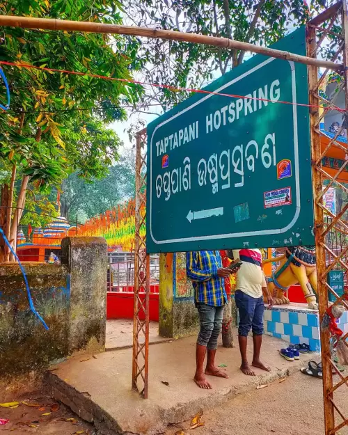 Taptapani Hot Spring signboard in Odisha surrounded by greenery and temple premises featured in Odisha tour packages
