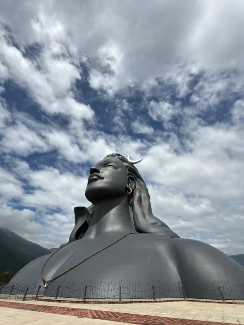 Majestic Adiyogi Shiva statue set against a dramatic cloudy sky in Coimbatore, Tamil Nadu, a spiritual landmark featured in Tamil Nadu tour packages.