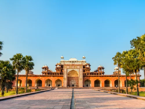 Akbar's Tomb Agra Uttar Pradesh grand sandstone entrance intricate jali work white marble inlays palm trees courtyard blue sky Mughal architecture UNESCO heritage site, perfect Golden Triangle heritage tour package