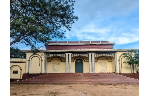 Aloka Palace. Historic colonial-style palace façade with arched doorways, pillars and grand steps in Mysuru, Karnataka.