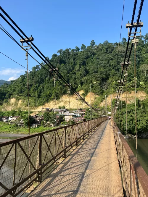 Suspension bridge in Daporijo Arunachal Pradesh over river with lush green hills showcasing scenic beauty in Arunachal Pradesh tour packages