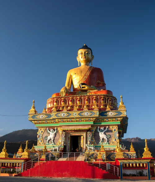 Giant golden Buddha statue at Tawang Monastery in Arunachal Pradesh with vibrant monastery architecture featured in Arunachal Pradesh tour packages