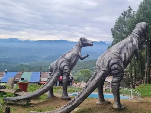 Ashiyana Park in Ranikhet, Uttarakhand featuring landscaped gardens and dinosaur statues overlooking the hills, a family-friendly attraction included in Uttarakhand tour packages 