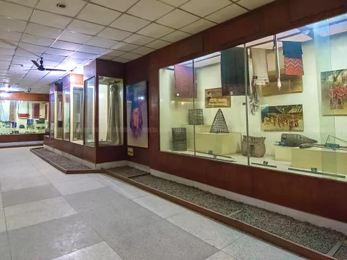 Traditional textiles artifacts at Assam State Museum Guwahati during daytime, featuring colorful fabrics baskets paintings displays, perfect cultural experience Assam tour package.