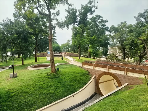 Scenic walkways at Atal Udyan Adabari Park Guwahati during cloudy day, featuring lush green lawns trees arch bridge, perfect family experience Assam tour package.