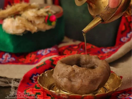Baadi, traditional Uttarakhand millet dough ball, served warm with ghee poured on top, rustic mountain comfort food.