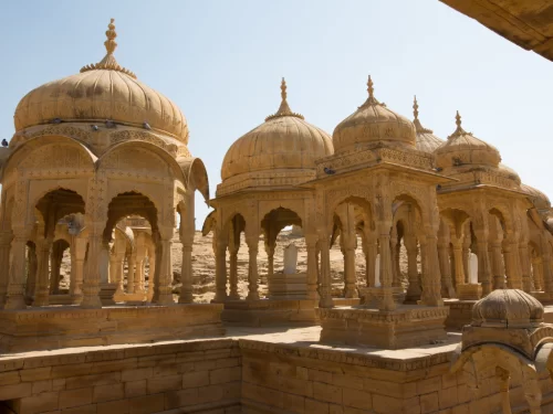 Bada Bagh Jaisalmer panoramic row of golden sandstone chhatris domes atop arid hill with sparse trees, Rajasthan Tour Packages. 