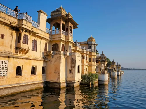 Bagore Ki Haveli waterfront view with traditional stone balconies and chhatris on Lake Pichola, Udaipur, Rajasthan.