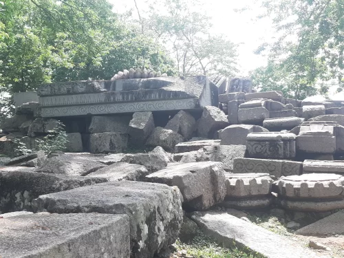 Bamuni Hills Tezpur ancient stone ruins sculpted pillars capitals friezes scattered boulders carvings trees sunlight Chitralekha Udyan park, perfect archaeological site Assam tour packages.