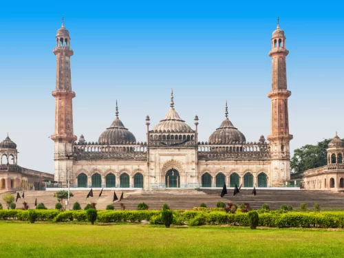 Bara Imambara at Lucknow during blue sky day, featuring red minarets domes lawns arches, perfect cultural Uttar Pradesh tour package.