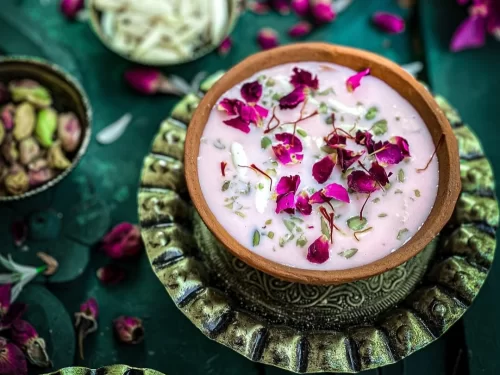 Basundi in thick saffron milk dessert with rose petals and pistachio garnish, authentic Indian sweet dish, rich Indian cuisine delight.
