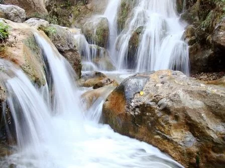 Bhatta Falls Mussoorie scenic waterfall cascading over rocks surrounded by lush greenery near Dehradun