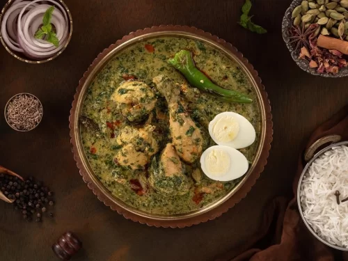 Bhopali Rezala in rich creamy spiced gravy with herbs and green chili garnish, authentic Indian chicken curry, steaming hot Indian cuisine delight.