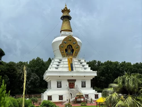 White Buddha Temple in Dehradun, Uttarakhand surrounded by greenery, a peaceful landmark featured in Uttarakhand tour packages