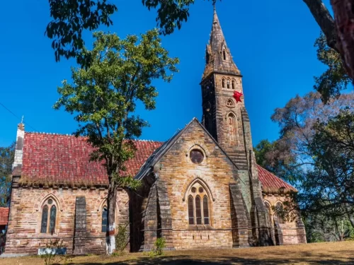 Historic Catholic Church in Pachmarhi, Madhya Pradesh, featuring stone architecture and a tall steeple surrounded by greenery, a peaceful heritage site often included in Madhya Pradesh tour packages.