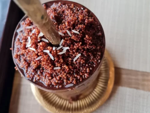 Chhang in mildly fermented millet drink with rice grain garnish, authentic Indian traditional beverage, refreshing Indian cuisine delight.