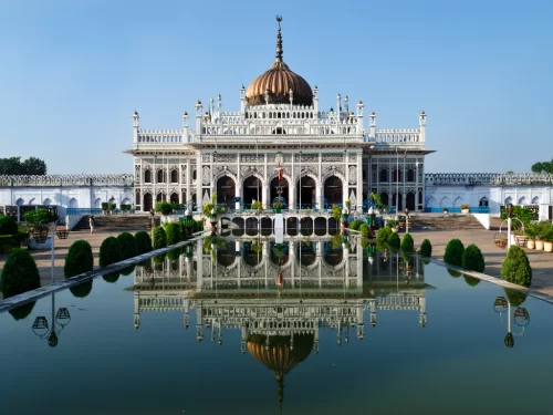 Chota Imambara palace reflection in pool at Lucknow during sunny day, featuring golden dome arches gardens trees, perfect cultural Uttar Pradesh tour package.