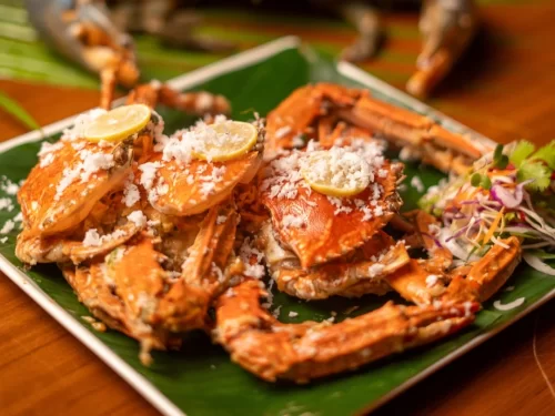 Sunset at Goa beach during evening, featuring palm trees and boats, perfect romantic experience Goa tour package.