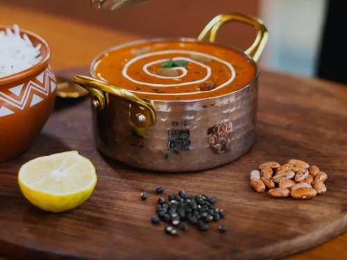 Dal Bukhara in rich creamy slow-cooked black lentil curry with butter swirl garnish, authentic Indian dal dish, steaming hot Indian cuisine delight.