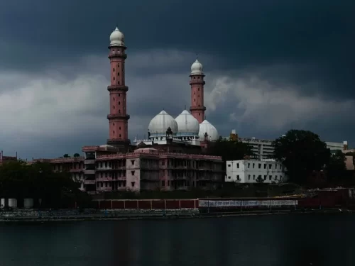 Taj-ul-Masjid in Bhopal, Madhya Pradesh, featuring its grand white domes and tall pink minarets overlooking the lake, a prominent architectural landmark included in Madhya Pradesh tour packages.