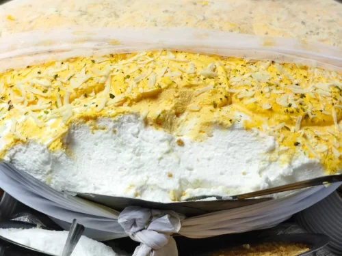 Daulat ki Chaat in airy saffron milk foam with grated khoya garnish, authentic Indian dessert chaat, melt-in-mouth Indian cuisine delight.